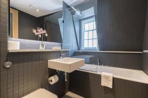 Stylish Stays by Russel Square في لندن: حمام مع حوض وحوض استحمام ومرحاض