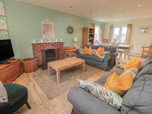 a living room with a couch and a fireplace at Sandy Cove in Chathill