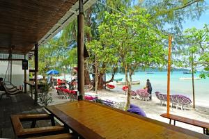 a beach area with umbrellas and chairs at Onederz Koh Rong Sanloem in Koh Rong Sanloem
