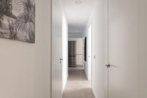 a hallway with white walls and a hallway with white doors at Royal Flats in Las Palmas de Gran Canaria