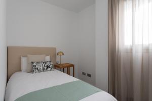 a bedroom with a bed with a pillow and a window at Royal Flats in Las Palmas de Gran Canaria