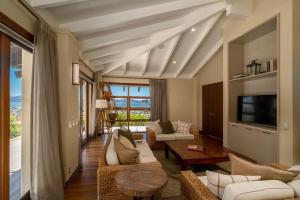 uma sala de estar com mobiliário branco e uma grande janela em Mercury Ridge em Cooks Beach