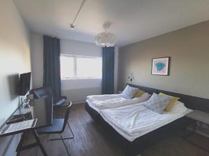 1 dormitorio con cama, escritorio y silla en Hotel Tingsryd en Tingsryd