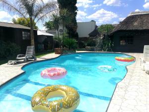 a swimming pool with two inflatable donuts in it at The Guesthouse in Vanderbijlpark