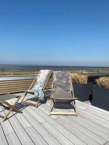 a boat sitting on top of a dock next to a beach at Hotel Strandhus in Cuxhaven