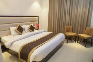 a hotel room with a large bed and two chairs at HOTEL AVI INN BY JR GROUP OF Hotels 50 Meter from Golden Temple in Amritsar