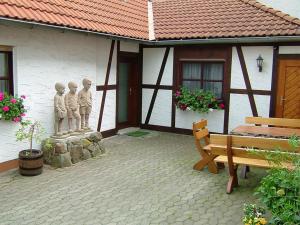 ein Gebäude mit einer Bank und zwei Statuen davor in der Unterkunft Vey'nes Ferienhaus & Vey'ne Ferienwohnung in Wüstensachsen