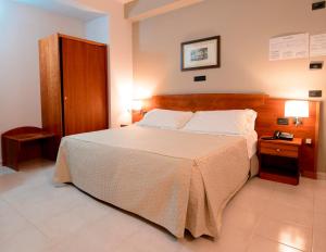 a bedroom with a large bed and a wooden headboard at Hotel dei Platani in Nola