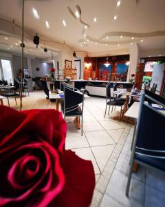 a restaurant with tables and chairs and a red rose at Residence Des Sources in Amnéville