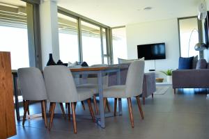 a dining room with a table and chairs at Pebble Beach 301 Penthouse, Sibaya in Sibaya +3 photos