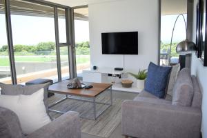 a living room with two chairs and a tv at Pebble Beach 301 Penthouse, Sibaya in Sibaya