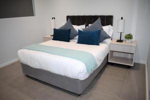 a bedroom with a large bed with blue pillows at Pebble Beach 301 Penthouse, Sibaya in Sibaya