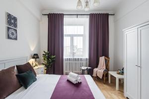 sypialnia z dużym łóżkiem z fioletowymi zasłonami w obiekcie GMApartments 3 nice bedrooms at Tverskaya w Moskwie