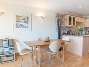 una cucina e una sala da pranzo con tavolo e sedie in legno di 1 Crabshell Quay a Kingsbridge