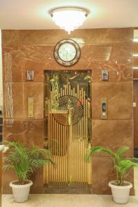 a lobby with a clock on a wall with plants at HOTEL AVI INN BY JR GROUP OF Hotels 50 Meter from Golden Temple in Amritsar