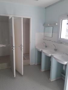 a bathroom with two sinks and a mirror at Centre de vacances La Salamandre in Arrens-Marsous