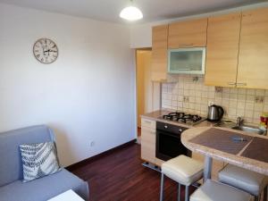 a small kitchen with a sink and a clock on the wall at Apartman Gobac in Karlovac