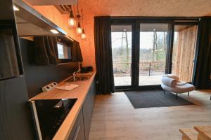 a kitchen with a counter and a chair and a window at Forest Cube in Oignies-en-Thierache