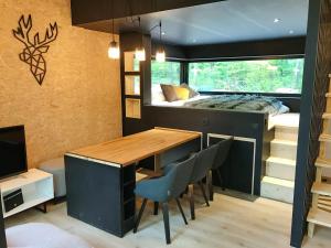 een tiny house met een bureau en een bed bij Forest Cube in Oignies