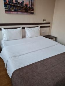 a bed with a white comforter and pillows at Hotel Karat in Kazan