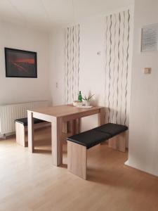 una mesa de madera y un banco en una habitación en Ferienwohnung Niklas, en Völklingen