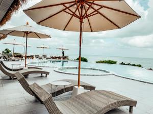 a pool with tables and chairs and an umbrella at High Life Bungalow in Haad Yao