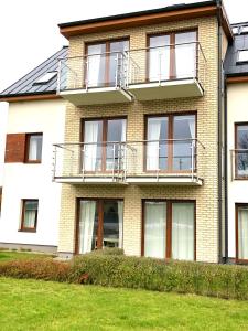 an apartment building with windows and a lawn at Golf Apartament 10 in Wejherowo +16 photos