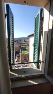 an open window with a view of a city at Hotel Logge Dei Mercanti in Monte San Savino