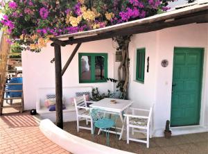 a table and chairs in front of a house with flowers at Vivienda Vacacional Buganvilla in Mácher