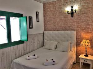 MácherにあるVivienda Vacacional Buganvillaのベッドルーム1室(ベッド1台、タオル2枚付)