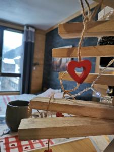 una señal de madera con un corazón rojo. en La Cabane en Chamonix-Mont-Blanc