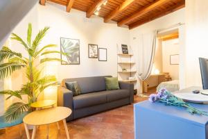 un soggiorno con divano e palma di San Fedele Apartment - Historical Como City Center by Rent All Como a Como