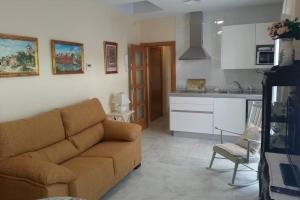 uma sala de estar com um sofá e uma cozinha em Apartamento clásico, cerca a Jardines de Murillo em Sevilha