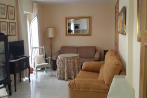 uma sala de estar com um sofá e uma mesa em Apartamento clásico, cerca a Jardines de Murillo em Sevilha