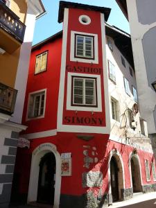 a red and white building with a sign on it at Gasthof Simony Hallstatt B&B in Hallstatt