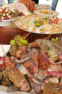 a buffet of food with seafood and vegetables on plates at Cala Rosa Club Hotel in Stintino