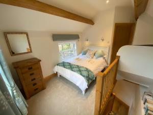 ein kleines Schlafzimmer mit einem Bett und einem Spiegel in der Unterkunft Robin Hood Tower in Crich