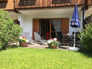 a patio with a table and a blue umbrella at Appartement Hildegard in Rieden