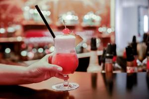 a person holding a drink in a glass at Hotel Europäischer Hof Hamburg in Hamburg