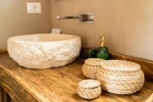 a bathroom with a sink and baskets on a wooden counter at Casa Stones B&B in Cugnana +18 photos