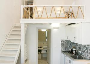 a loft bed in a kitchen with a staircase at Kallichoron Art Boutique Hotel in Astypalaia