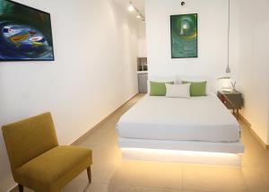 1 dormitorio con 1 cama y 1 silla en Kallichoron Art Boutique Hotel en Astipalea