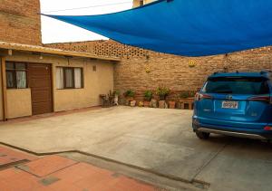 a blue van parked in a parking lot at Rosales Norte Apartamentos GCH in Cochabamba