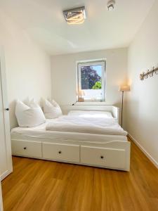 a large white bed in a room with a window at Meerestraum in Grömitz