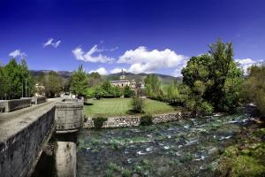 a bridge over a river with a house in the background at Casa Etna in Rascafría