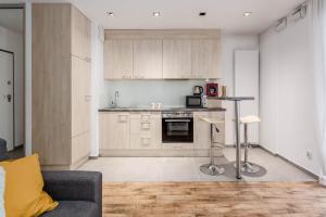 a kitchen with a couch and a table in a room at Chill Apartments Wola Center in Warsaw