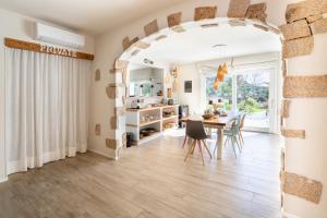 a kitchen and dining room with an archway and a table at Casa Stones B&B in Cugnana