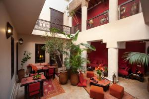 a large living room with red furniture and plants at Riad Boussa in Marrakesh