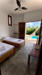 a bedroom with two beds and a view of a pool at Bambo Villa in Paracuru