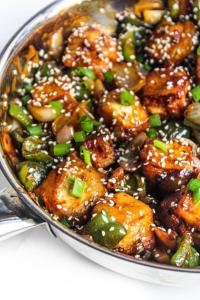 a dish of sesame chicken with mushrooms and green onions at HOTEL AVI INN BY JR GROUP OF Hotels 50 Meter from Golden Temple in Amritsar